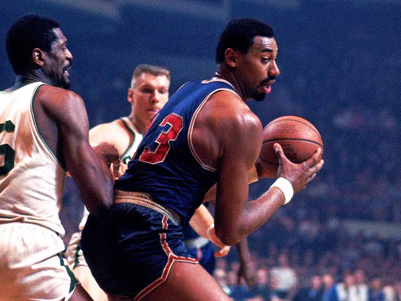 Wilt Chamberlain of Philadelphia 76ers being blocked by opponents during game play in the court